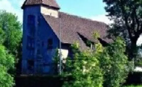 Vue de l'extérieur du Château de Einhartshausen entouré d'arbres et de buissons.