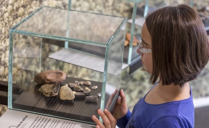 une fille devant une exposition d'archéologie